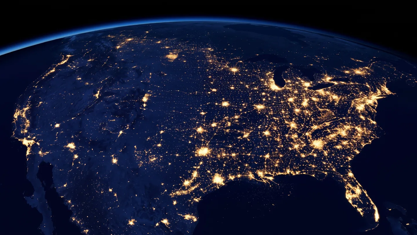 The United States at night seen from orbit, city lights glowing from coast to coast.