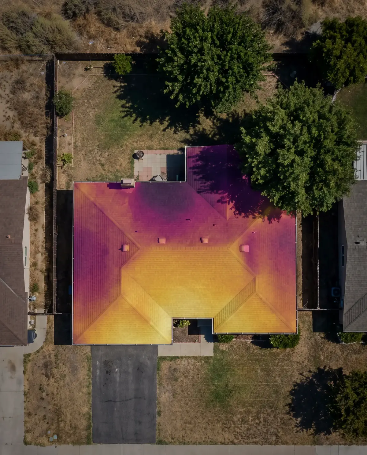 Example roof sun map: a satellite view of a house with its roof shaded gold where the sun is strongest and purple where it is weakest.